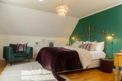 a bedroom with a large bed and a green wall at Duveslätt B & B in Åskloster