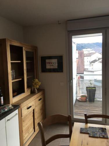une cuisine avec une table et une porte coulissante en verre. dans l'établissement Appartement centre-ville, à Annecy