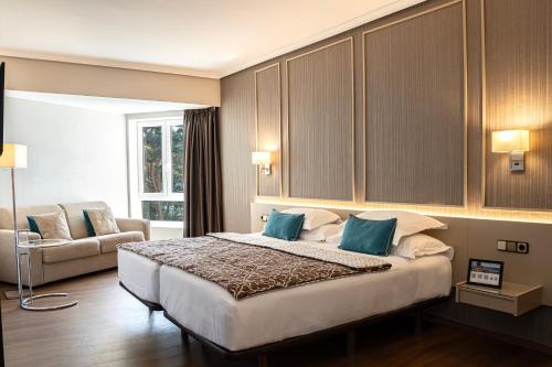 a bedroom with a large bed and a couch at Mercure Monte Igueldo in Donostia-San Sebastián