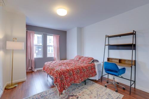 um quarto com uma cama e uma cadeira azul em Philadelphia Apartment, Near Transit and Sites! em Filadélfia