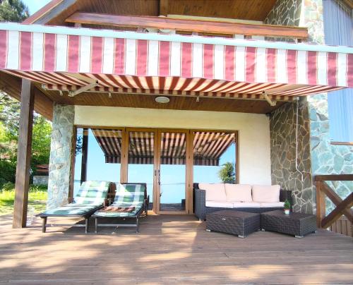 awning over a patio with two chairs and a couch at chata ,,Na Brehu'' in Klokočov