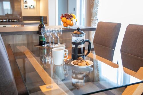 a glass table with a coffee maker and a bowl of food at Stewarts Resort Lodge 26 in St. Andrews