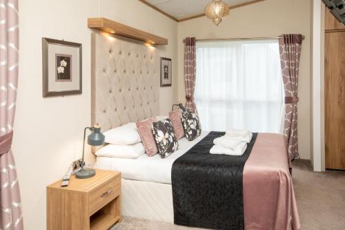 a small bedroom with a bed and a window at Hot Tub Lodge 26 Cameron, St Andrews in St. Andrews