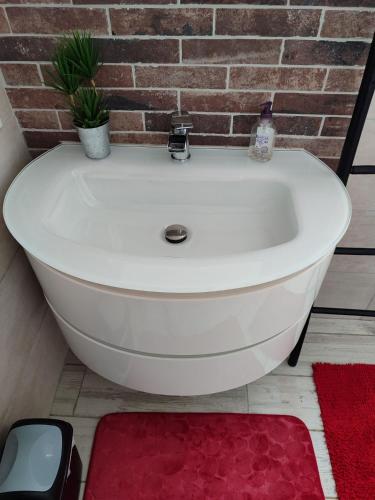 La salle de bains est pourvue d'une baignoire blanche et d'un mur en briques. dans l'établissement Gîte et Chambre d'hôte Entre Tilleul et Agrumes, à Vinassan