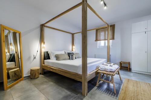 een slaapkamer met een hemelbed en een tafel bij Casa Naturale in Skopelos Town