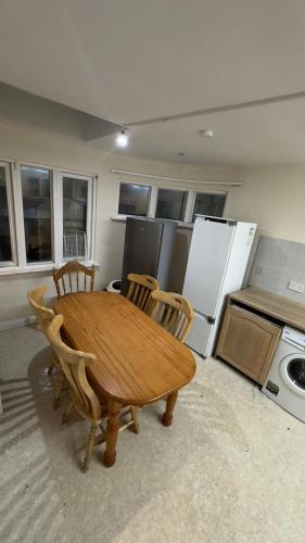 eine Küche mit einem Holztisch und 4 Stühlen in der Unterkunft Nice Double Room Clontarf House-1 in Dublin