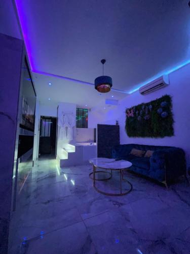歐貝維列的住宿－Le BLUE，客厅配有桌子和紫色灯