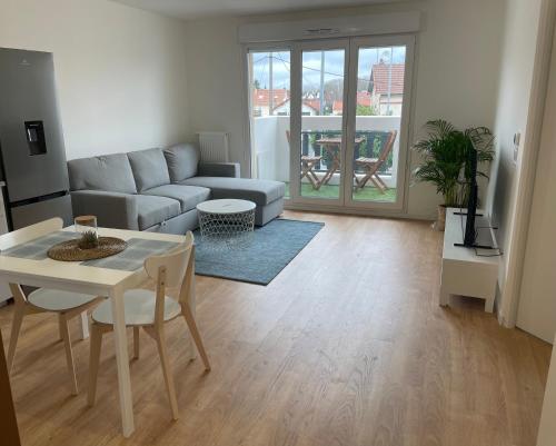 un salon avec un canapé et une table dans l'établissement Appartement Cosy proche PARIS CDG parking, au Blanc-Mesnil