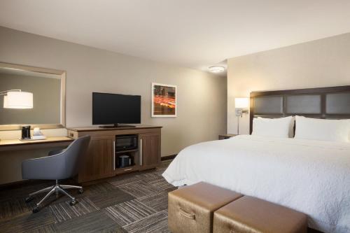 Habitación de hotel con cama y TV de pantalla plana. en Hampton Inn & Suites Minooka, en Channahon