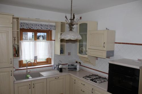 een keuken met witte kasten en een wastafel bij Sosta in Sila in Spezzano Piccolo