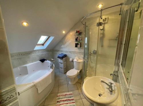 a bathroom with a tub and a toilet and a sink at Cosy Rooms in a Stone Cottage in Galway