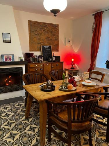 a dining room with a table and chairs and a fireplace at Maison d'Hôtes & Savonnerie de Bonnefon in Saint-Chély-dʼAubrac