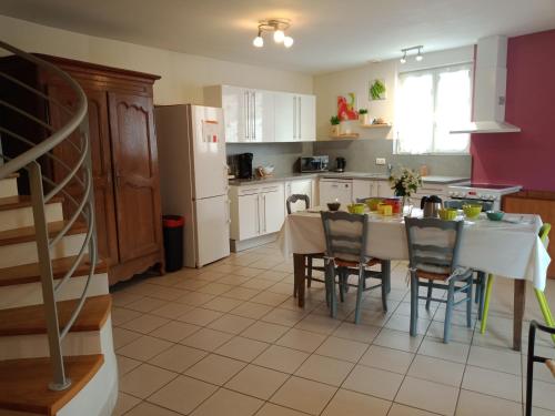 Il comprend une cuisine équipée d'une table et de chaises. dans l'établissement Gite Peronne en baie du Mont st Michel, à Champeaux