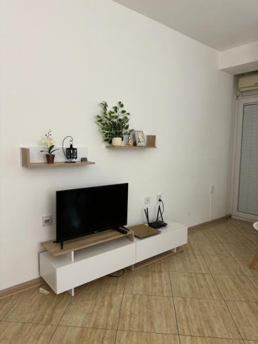 a living room with a flat screen tv on a white wall at Gold Apartment in Ohrid