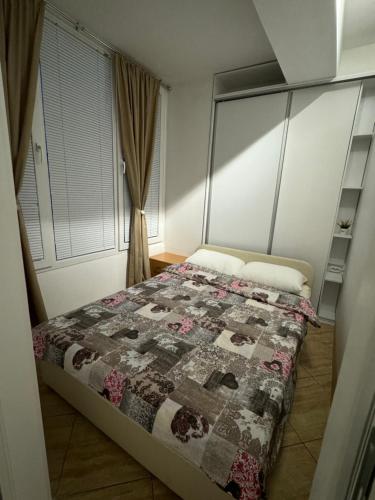 ein Schlafzimmer mit einem Bett mit einer Decke darauf in der Unterkunft Gold Apartment in Ohrid