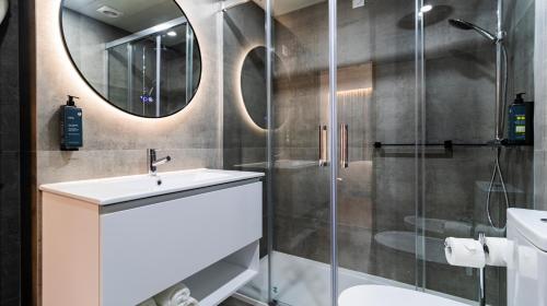 W łazience znajduje się prysznic, umywalka i lustro. w obiekcie Albergaria Quim Barreiros w mieście Vila Praia de Âncora