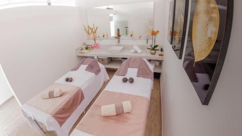 a room with two beds and a table with a mirror at Hotel Le Falep & Spa in Anapoima