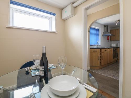 a glass table with a bottle of wine and glasses at Flat 1 Marina Court in Redruth