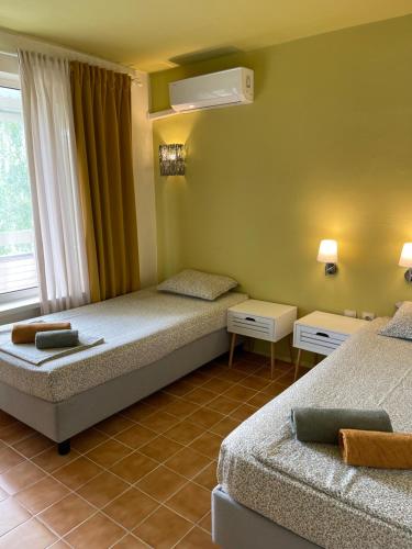 AMADINA GARDEN - Bed & Breakfast or Half Board في لوزينيتس: غرفة فندقية بسريرين ونافذة