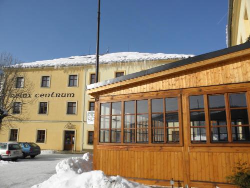 a building with a building with snow in front of it at Kolštejn wellness centrum in Branná