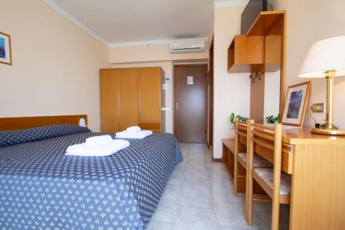 a hotel room with a bed and a desk and a room at Hotel Benacus Torri del Benaco in Torri del Benaco