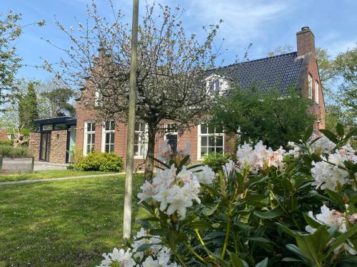 a garden with flowers in front of a brick building at Villa Royale in Oranjewoud