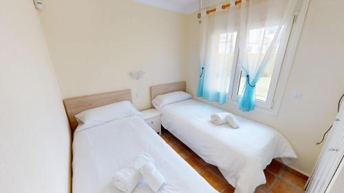 - 2 lits dans une petite chambre avec fenêtre dans l'établissement Levante by Oliva Nova, à Oliva