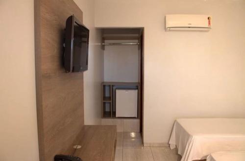 アラグァイーナにあるHotel Ipanemaの小さな客室で、テレビ、ベッドが備わります。