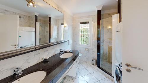 Un baño con dos lavabos y una ducha. en Villa Golden by ON Travel, en Oliva