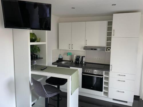 a kitchen with white cabinets and a counter with a sink at Messewohnung in Hannover