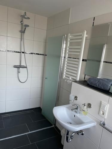 a bathroom with a sink and a shower and a mirror at Ferienwohnung mit Fußbodenheizung nahe Messe, gratis Parkplatz und Abstellplatz E - Bike in Hannover