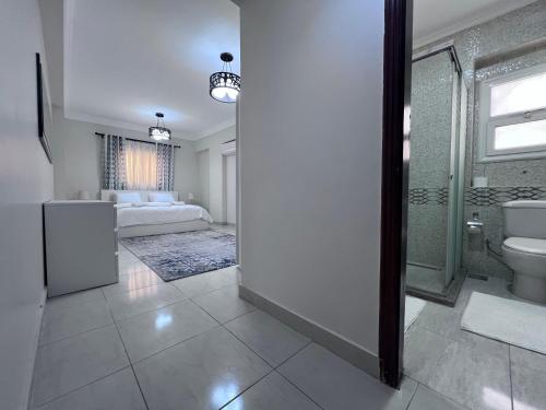 een badkamer met een toilet en een douche en een slaapkamer bij Home2Home in Caïro