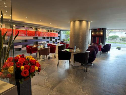 un restaurant avec des tables, des chaises et des fleurs dans l'établissement Rioné Hotel Boutique, à Cuenca