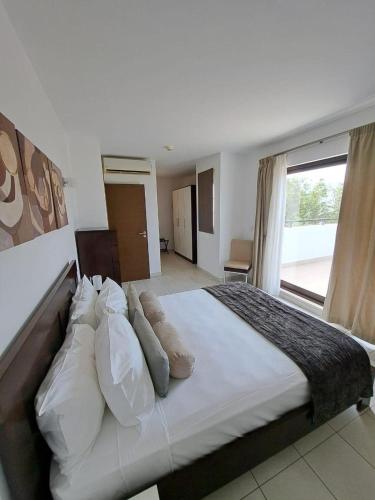 聖瑪麗亞的住宿－Spacious family friendly 3-Bed Villa Dunas Resort，卧室配有一张带白色床单和枕头的大床。