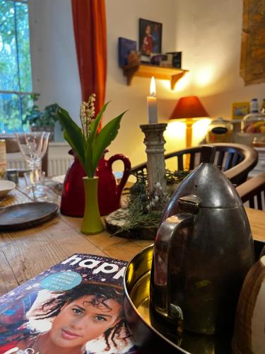 a dining room table with a table top with a tea kettle at Maison d'Hôtes & Savonnerie de Bonnefon in Saint-Chély-dʼAubrac
