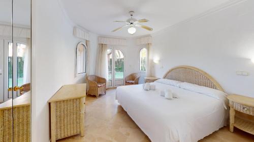 um quarto com uma grande cama branca e uma mesa em Villa Aranjuez by Oliva Nova em Oliva