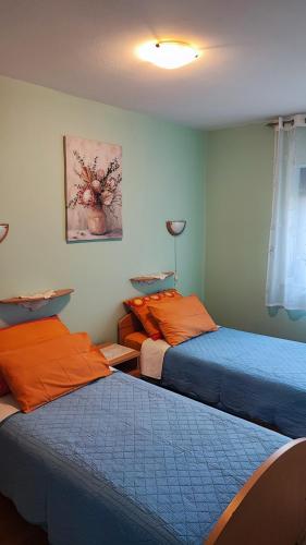 two beds in a room with blue and orange at Apartments Anić in Novigrad Istria