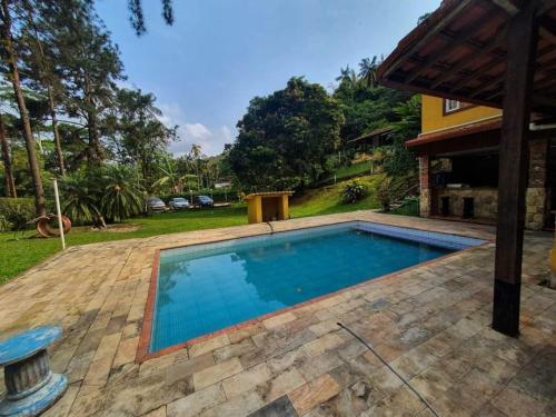 una piscina en el patio trasero de una casa en Guest House sítio do Sol Penedo, en Penedo