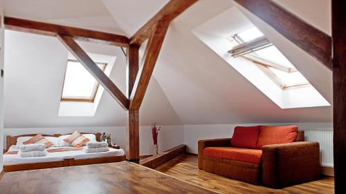 a attic bedroom with a bed and a chair at Kolštejn wellness centrum in Branná