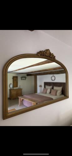 a mirror reflecting a bedroom with a bed in it at La Perle de la Lauzière, chambres d hôtes in Argentine