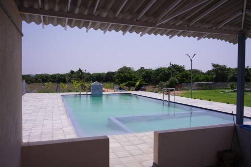een groot zwembad in een paviljoen bij Green Mango Farmhouse in Chityāl