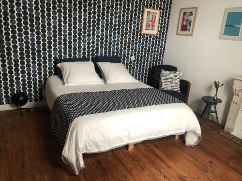 a bedroom with a bed with a black and white patterned wall at La Sirène in Grand-Village-Plage