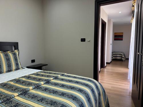 a bedroom with a bed and a hallway at Rritja e Koranit in Pogradec