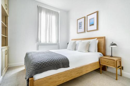 倫敦的住宿－Lovely Spot by City of London，白色的卧室设有一张大床和一个窗户