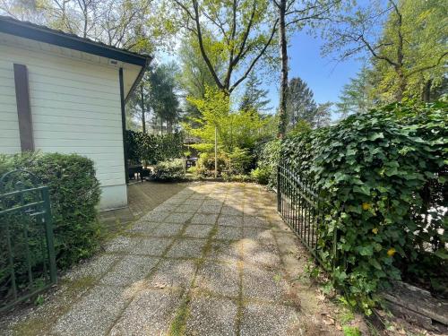 a driveway leading to a house with a fence at VELUWSHOF HOENDERLOO HOLIDAYS Luxe Holidayhomes with PRIVATE JACUZZI'S - SwimmingPool - Tennis Court - Bowling - Supermarket and Children Entertainment in Hoenderloo