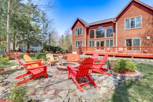 a group of red chairs in front of a house at Fire Pit and BBQ Elegant Split Rock Resort Getaway! in Lake Harmony