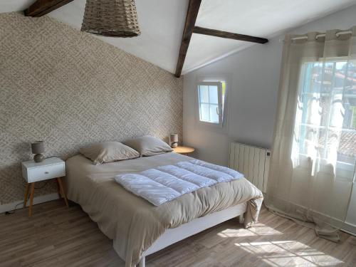 una camera con un grande letto e una finestra di Maison 10km du puy du fou 50 m2 a Mortagne-sur-Sèvre