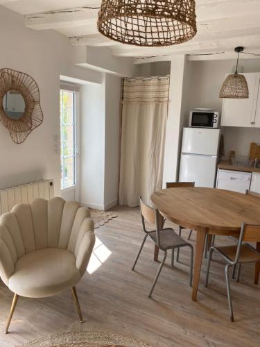 une cuisine et une salle à manger avec une table et des chaises dans l'établissement Maison 10km du puy du fou 50 m2, à Mortagne-sur-Sèvre