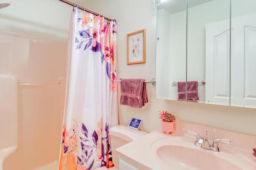a bathroom with a sink and a shower curtain at Fire Pit and BBQ Elegant Split Rock Resort Getaway! in Lake Harmony