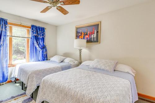 a bedroom with two beds and a ceiling fan at Fire Pit and BBQ Elegant Split Rock Resort Getaway! in Lake Harmony